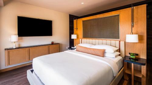 a bedroom with a large white bed and a flat screen tv at L'Auberge De Sedona in Sedona