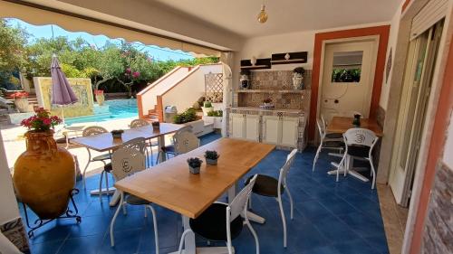 a kitchen and dining room with tables and chairs at Anastasia Villas-B&B in Lido Signorino