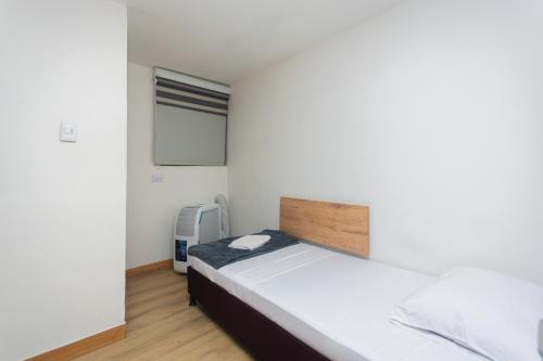 a small bedroom with a bed and a window at Hotel Lares 70 Laureles in Medellín