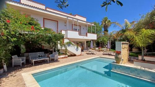 a villa with a swimming pool in front of a house at Anastasia Villas-B&B in Lido Signorino