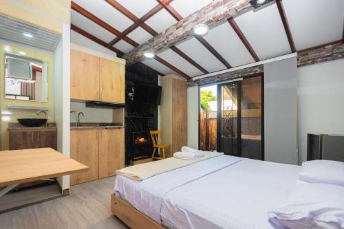 a bedroom with a large bed and a kitchen at Hotel Lares 70 Laureles in Medellín