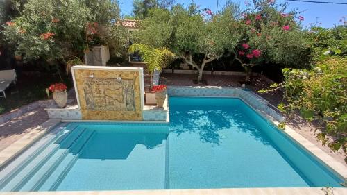 a swimming pool with a fountain in a yard with trees at Anastasia Villas-B&B in Lido Signorino