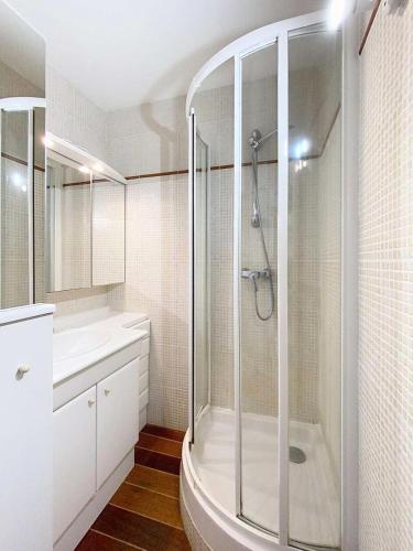 une salle de bain blanche avec une douche et un lavabo dans l'établissement Résidence Casino - Studio 2 personnes proche plages à Lacanau Océan MAE-0411, à Lacanau