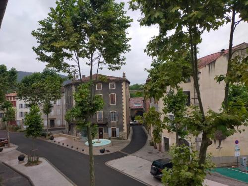 una strada in una città con edifici e alberi di Au coeur de Chalabre, bastide médiévale, près du lac de Montbel a Chalabre