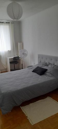 une chambre avec un lit, un bureau et une lampe dans l'établissement Appartement Val André, à Le Port-Marly