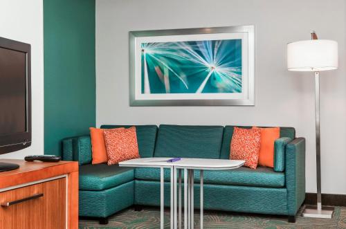 a living room with a couch and a table at SpringHill Suites Boston Peabody in Peabody