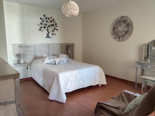 - une chambre avec un lit blanc et des oreillers dans l'établissement Havre de paix au cœur du Sud appartement cosy climatisé piscine privée entre mer et trésors du Languedoc, à Puissalicon