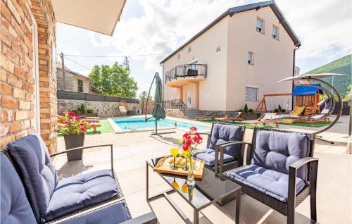 a patio with chairs and a table and a pool at 3 Bedroom Stunning Apartment In Gracac in Gračac