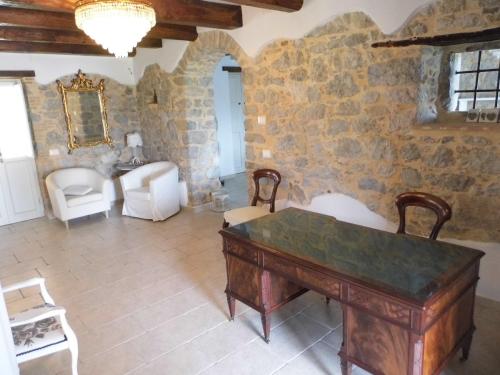 a room with a table and chairs and a stone wall at Aia Antica in Monte San Biagio