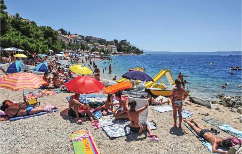 a crowd of people on a beach with umbrellas at Beautiful Apartment In Podgora in Podgora