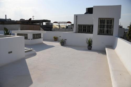 a white building with a courtyard on the roof at Dar Hamouda Guest House - Médina de Tunis in Tunis
