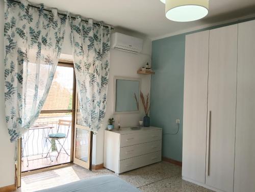 a bedroom with a sliding glass door with a window at Limpida Casa Vacanza in San Nicola Arcella