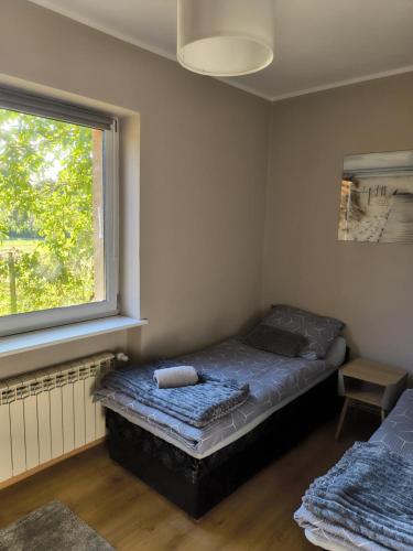 a bedroom with a bed and a window at Nocleg pod Orzechem Apartament z 2 pokojami in Wapnica