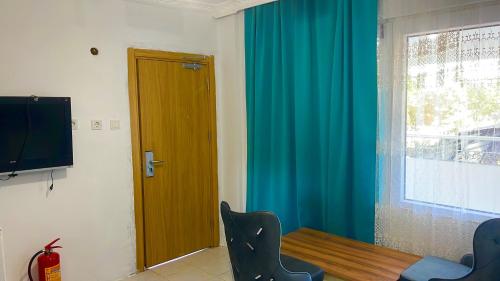 a room with a table and a television and a window at Erikli Golden Glow P Hotel in Eskiömerler