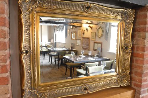 an ornate gold mirror reflecting a dining room at The Royal Oak in Loughborough