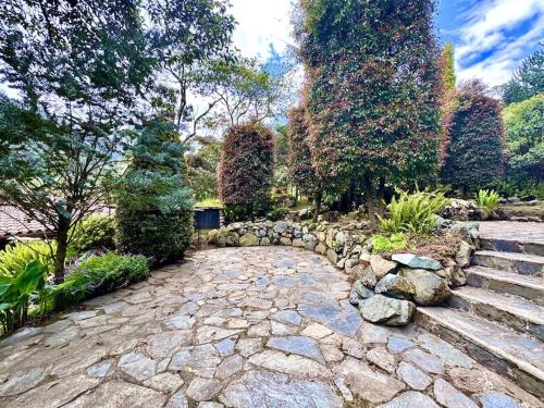 a stone path in a garden with trees and bushes at Heated & Cozy Cabin in Nature in Cuenca