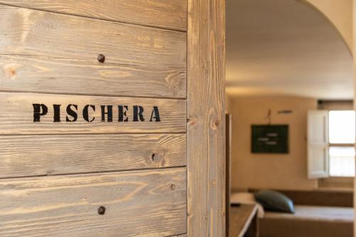 a wooden door with the word piscina written on it at Bixinau Camere Museo in Tortolì