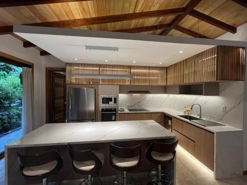 a kitchen with a large island with bar stools at Heated & Cozy Cabin in Nature in Cuenca