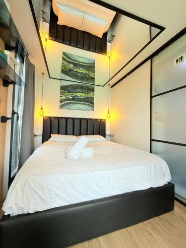 a bedroom with a large bed with white sheets at 446 Tiny House Shirokë in Široka