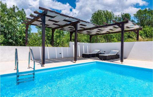 a pergola over a swimming pool with a patio at Awesome Home In Ribnica - Krusevo in Anić