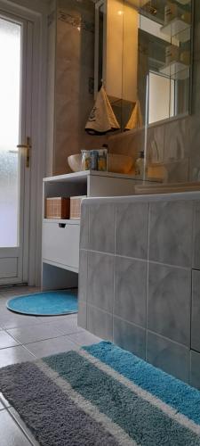 une cuisine avec un évier et un comptoir avec un miroir dans l'établissement Appartement Val André, à Le Port-Marly