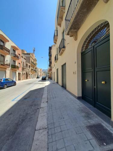 an empty street with two large doors on a building at 32Venti Comfort Apartments Trapani in Trapani