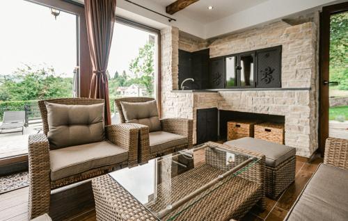 a living room with wicker chairs and a fireplace at Lovely Home In Lepoglava With Sauna in Lepoglava