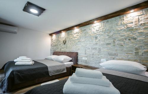 a room with two beds and a stone wall at Lovely Home In Lepoglava With Sauna in Lepoglava