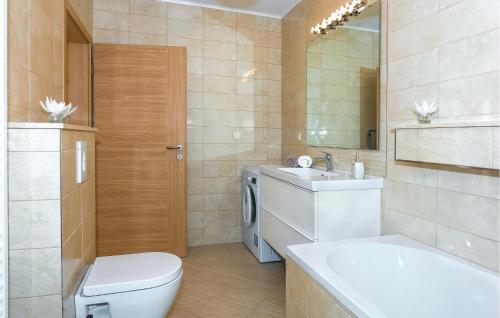a bathroom with a toilet and a sink and a tub at 3 Bedroom Awesome Home In Badanj in Drniš