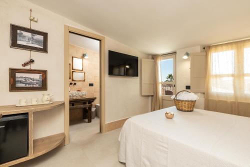 a hotel room with a bed and a television at Bixinau Camere Museo in Tortolì