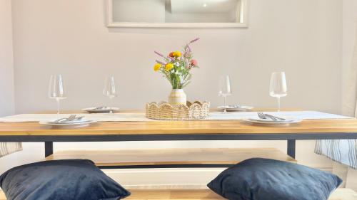 a dining room table with a vase of flowers on it at The Bank in West Kirby