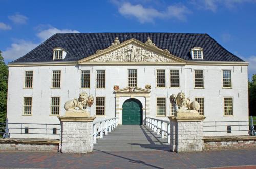 a large white building with a green door at Kleine Austernperle in Dornumersiel