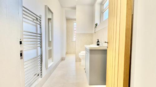 a bathroom with a white toilet and a sink at The Bank in West Kirby
