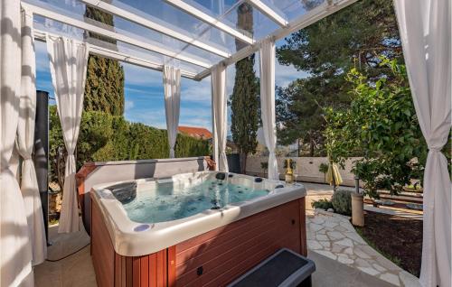 a hot tub in a conservatory with a window at 3 Bedroom Beach Front Home In Zdrelac in Ždrelac