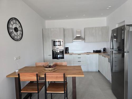 a kitchen with a wooden table with chairs and a refrigerator at Mystic Heaven in Mýkonos City