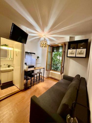 a living room with a couch and a kitchen at Studio moderne et chaleureux au coeur de Geneve - parfait pour courts sejours in Geneva