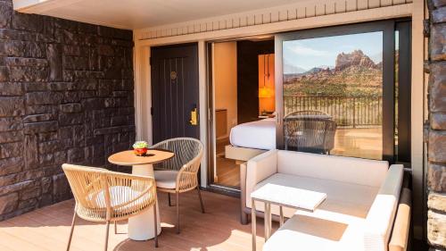 a room with a balcony with a bed and a table and chairs at L'Auberge De Sedona in Sedona