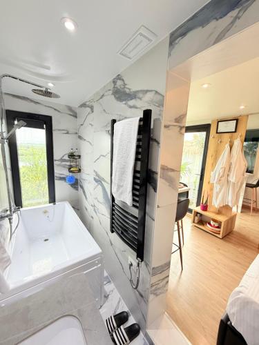 a bathroom with a white tub and a sink at 446 Tiny House Shirokë in Široka