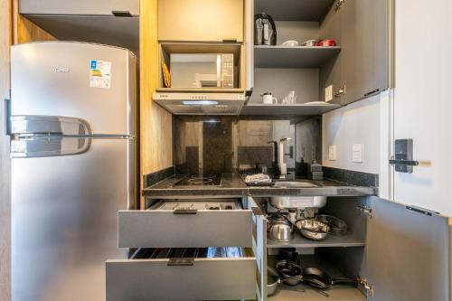 a small kitchen with a stainless steel refrigerator at Skyline Parque Moinhos by LikeHome in Floresta