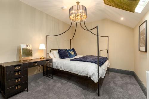 a bedroom with a bed and a desk and a chandelier at The Library Suite in Marske