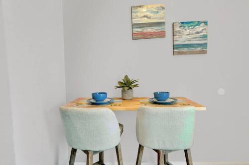 a dining room table with two chairs and a table with two cups at The Dolphin Watch Near the Beach in FWB - Unit 7 in Fort Walton Beach