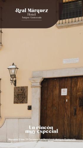 a building with a wooden door and a sign on it at Real Marquez Hotel in Antigua Guatemala