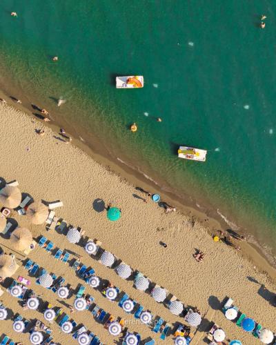 an overhead view of a beach with umbrellas and the ocean at 446 Tiny House Shirokë in Široka