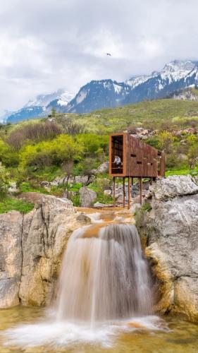 a waterfall next to a small waterfalliterator at 446 Tiny House Shirokë in Široka
