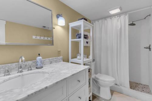 a bathroom with a sink and a toilet and a mirror at 26 Muirfield Road at The Sea Pines Resort in Hilton Head Island
