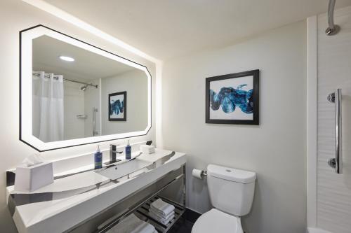 a white bathroom with a sink and a mirror at Four Points by Sheraton Englewood Centennial Airport in Englewood