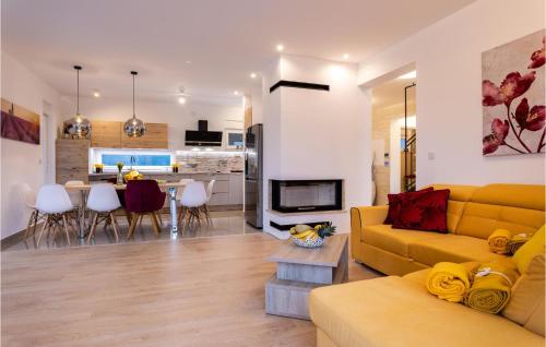 a living room with a yellow couch and a kitchen at Cozy Home In Klimno With Wifi in Klimno