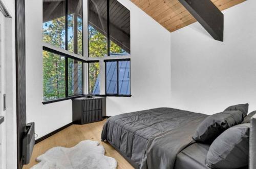 a bedroom with a bed and large windows at Modern Mountain Luxury Soak, Stay, & Be Spoiled in Shaver Lake