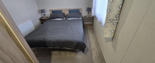 a small room with two beds and a window at J2 static caravan at Fairway Holiday Park in Sandown