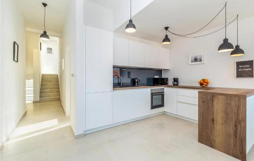una cucina con armadietti bianchi e un bancone in legno di 3 Bedroom Beautiful Home In Njivice a Njivice